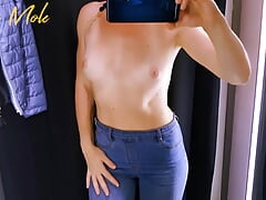 A girl with a perfect figure in jeans, shows her small beautiful breasts